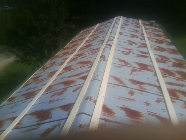 Rusted metal roof panels with new wood purlins before replacement — Storm Damage Roof Repair in Big Piney by Roofing Brothers
